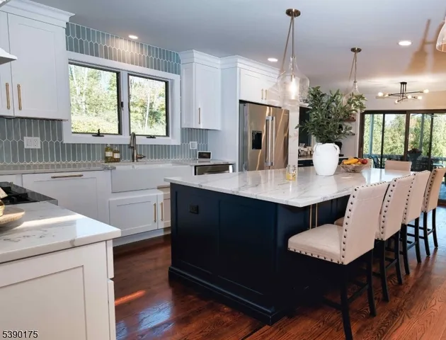 a kitchen with a kitchen island hardwood floor sink stove dining table and chairs