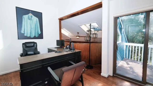 a view of a hallway with furniture and wooden floor