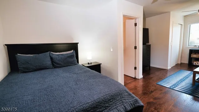 a spacious bedroom with a bed and wooden floor