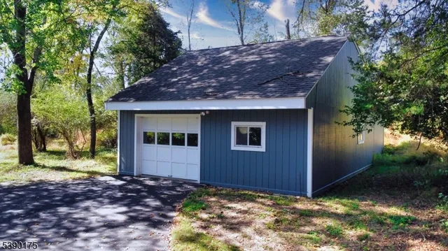a view of a house with a yard and large tree