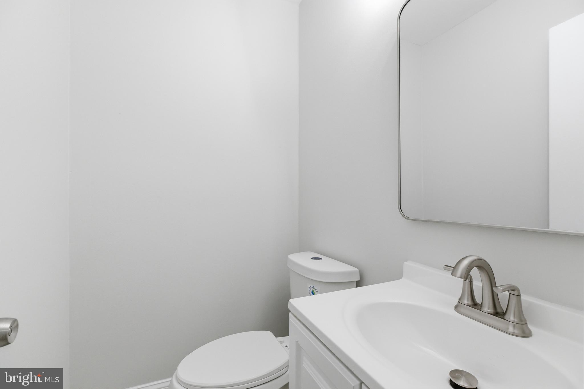 14033 Grayson Road Woodbridge, VA 22191 - Photo 17 of 33 a bathroom with a toilet sink and mirror