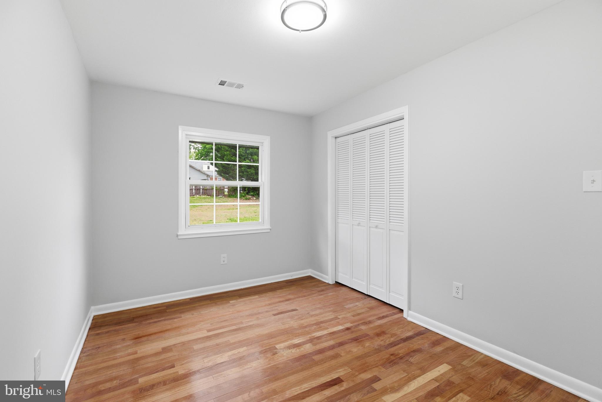 14033 Grayson Road Woodbridge, VA 22191 - Photo 18 of 33 an empty room with wooden floor and windows