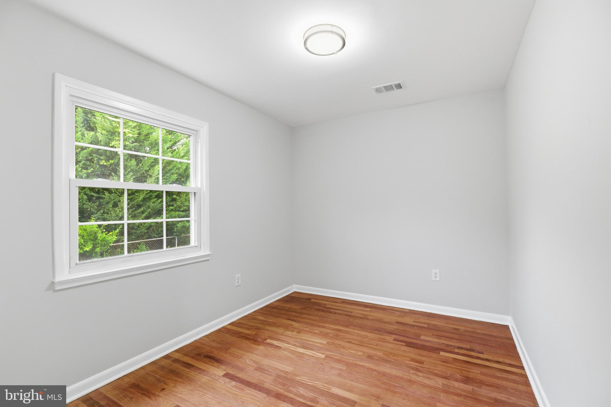 14033 Grayson Road Woodbridge, VA 22191 - Photo 21 of 33 an empty room with wooden floor and windows