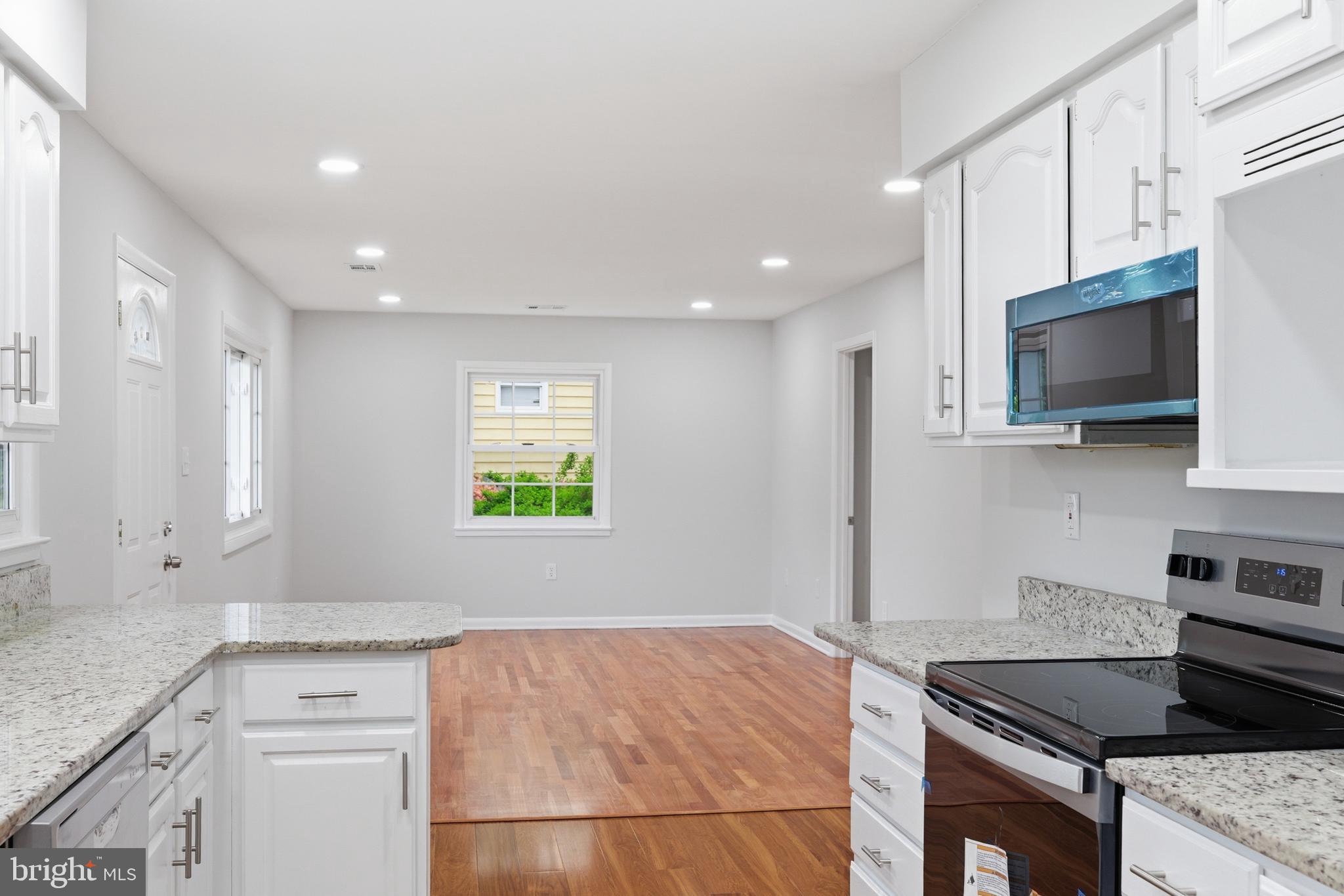 14033 Grayson Road Woodbridge, VA 22191 - Photo 10 of 33 a kitchen with stainless steel appliances granite countertop a stove a sink and a microwave