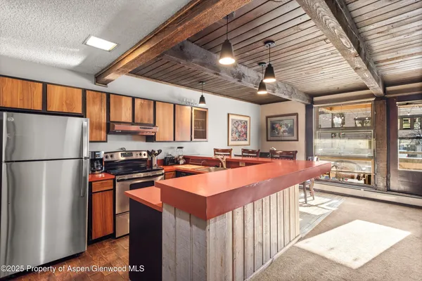 a large kitchen with stainless steel appliances granite countertop a stove refrigerator a sink and dishwasher with wooden floor