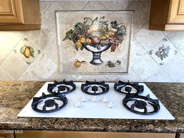 a kitchen with a stove and wooden floor