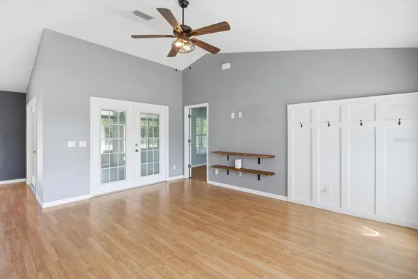 a view of a livingroom with wooden floor and a ceiling fan