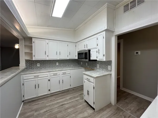 a kitchen with stainless steel appliances granite countertop a stove a sink and white cabinets