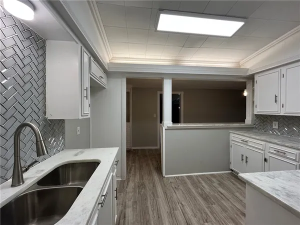 a kitchen with cabinets and wooden floor