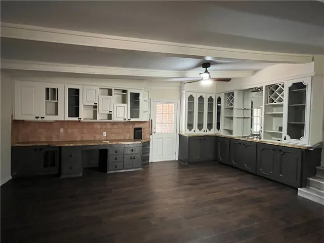 a living room with stainless steel appliances kitchen island granite countertop wooden floors and view living room