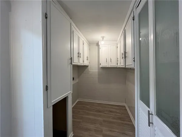 a view of empty room with wooden floor