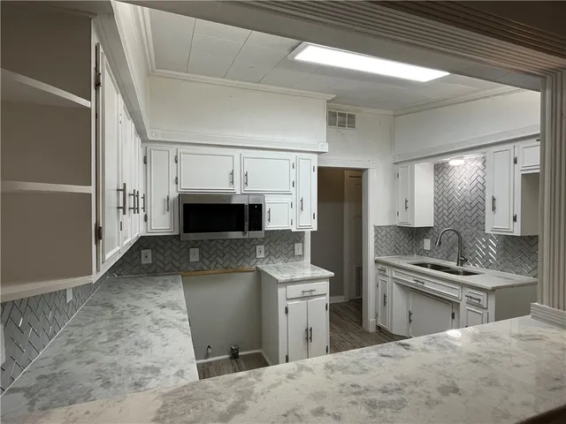 a kitchen with stainless steel appliances kitchen island granite countertop a refrigerator stove and sink