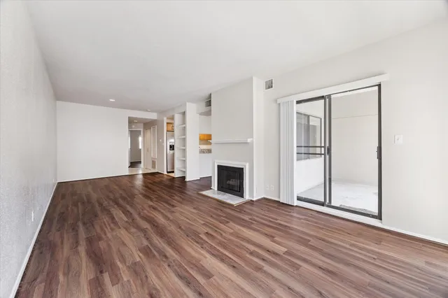 a view of a livingroom with wooden floor and fireplace