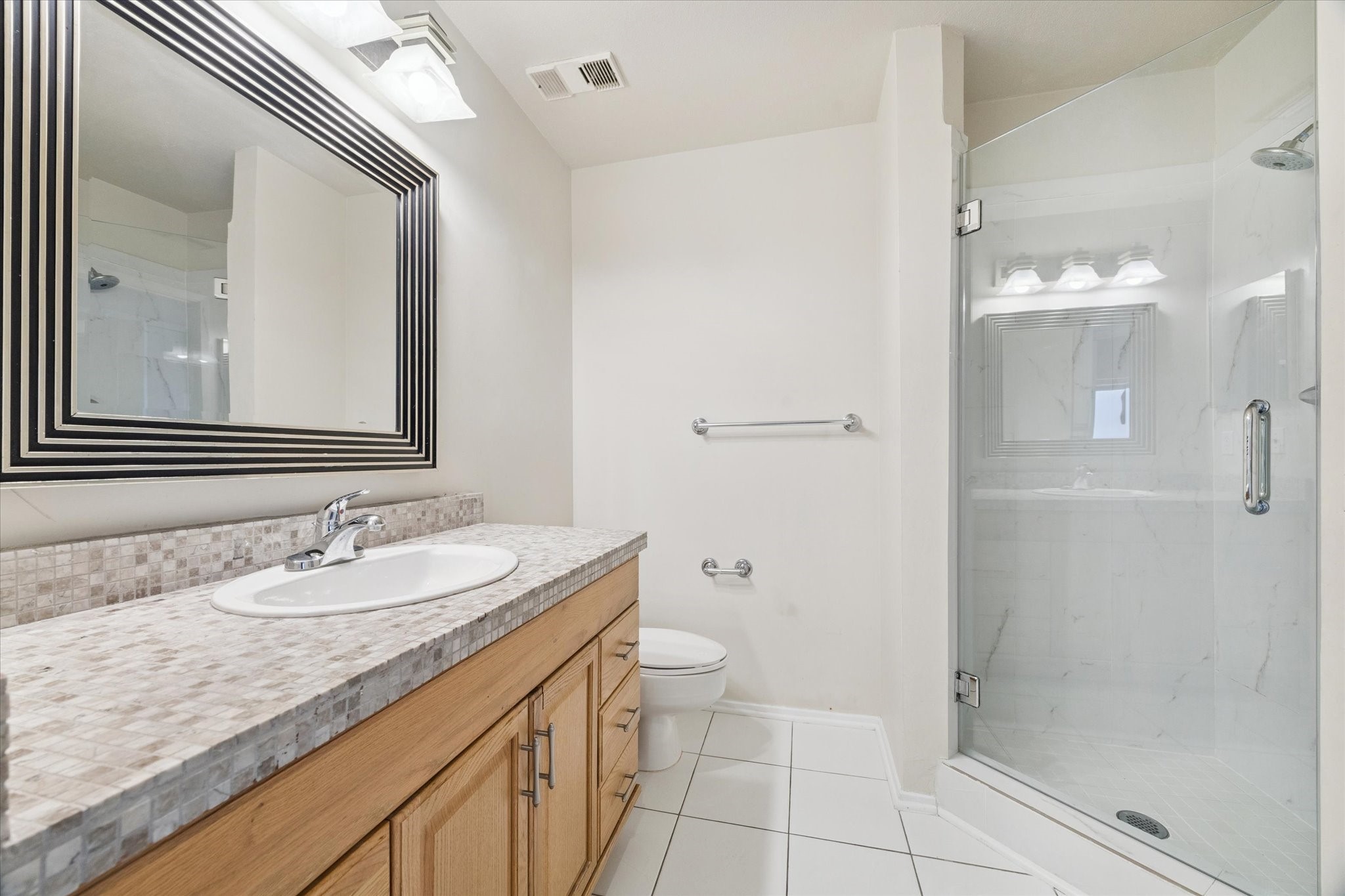 1819 Augusta Drive, Unit C28 Houston, TX 77057 - Photo 3 of 17 a bathroom with a granite countertop sink a mirror and a shower