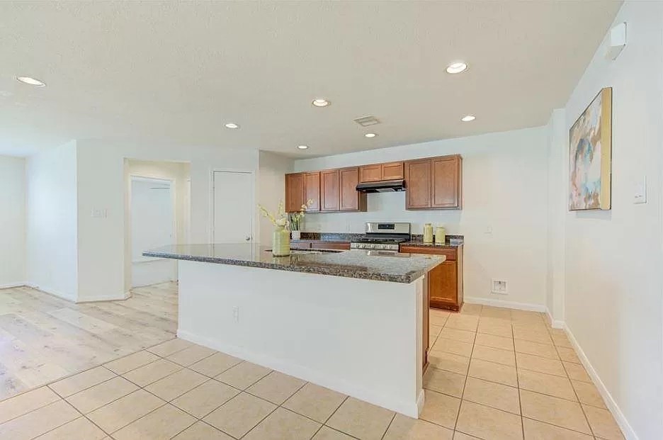 a kitchen with stainless steel appliances granite countertop a refrigerator and a sink