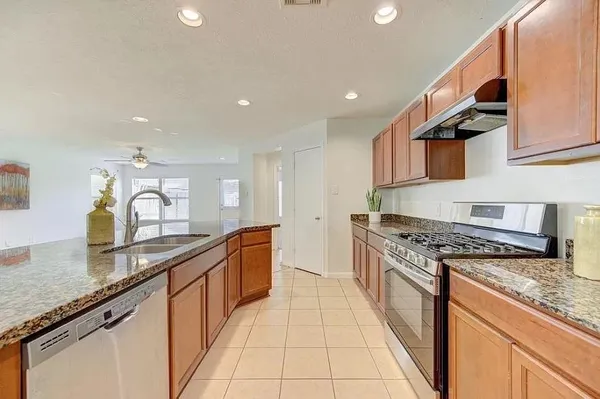 a large kitchen with stainless steel appliances granite countertop a sink and cabinets