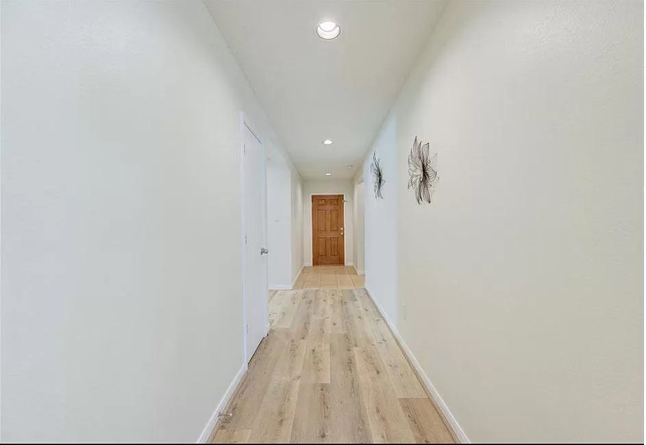 15331 Keystone Bend Lane Cypress, TX 77429 - Photo 6 of 18 a view of a hallway with wooden floor and a bathroom