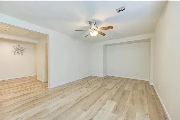a view of empty room with wooden floor