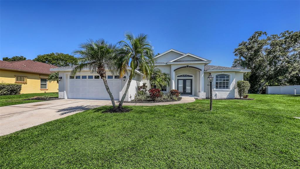 a view of a house with a yard and palm trees