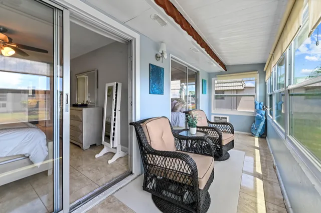 a living room with furniture and a floor to ceiling window