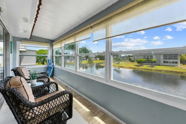 a living room with furniture and a floor to ceiling window
