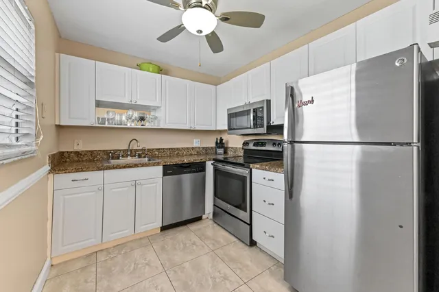 a kitchen with cabinets stainless steel appliances and a window