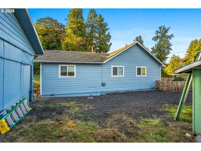 a front view of house with yard and trees in the background