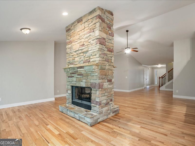 1406 Morgans Bluff Monroe, GA 30656 - Photo 11 of 80 an empty room with wooden floor fireplace and windows