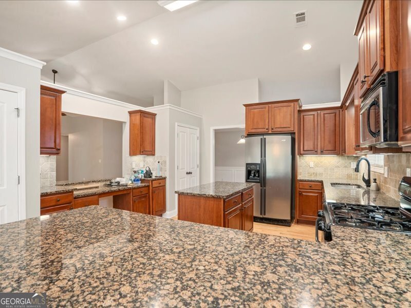 1406 Morgans Bluff Monroe, GA 30656 - Photo 14 of 80 a large kitchen with stainless steel appliances kitchen island granite countertop a refrigerator and a stove top oven