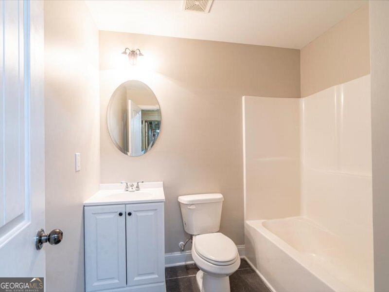 1406 Morgans Bluff Monroe, GA 30656 - Photo 51 of 80 a bathroom with a toilet sink vanity tub and mirror
