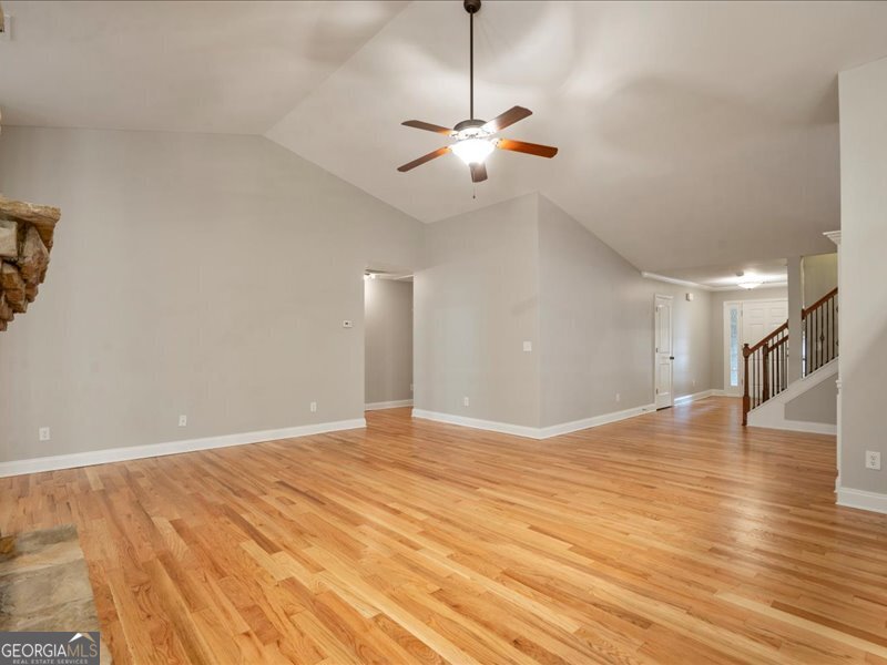 1406 Morgans Bluff Monroe, GA 30656 - Photo 10 of 80 a view of an empty room with wooden floor and a ceiling fan