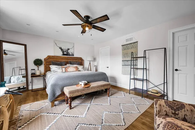 a bedroom with a bed a dresser and a chandelier