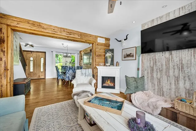 a dining room with furniture a floor to ceiling window and wooden floor