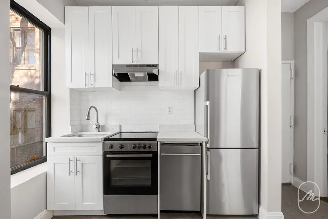 a view of a kitchen with a sink and a refrigerator