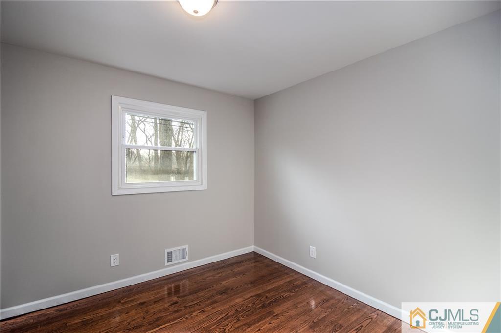 3034 Cheesequake Road Old Bridge, NJ 08859 - Photo 14 of 28 an empty room with wooden floor and windows