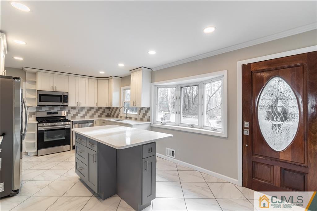 3034 Cheesequake Road Old Bridge, NJ 08859 - Photo 3 of 28 a large kitchen with kitchen island granite countertop a sink a stove and a wooden floors