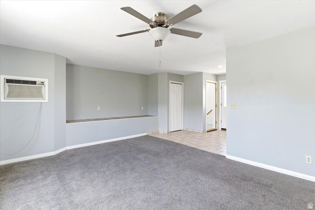 1613 Sunset Road Lake Point, UT 84074 - Photo 6 of 33 Spacious living area featuring gray carpeting, light gray walls, a built-in window air conditioning unit, and a ceiling fan with integrated lighting