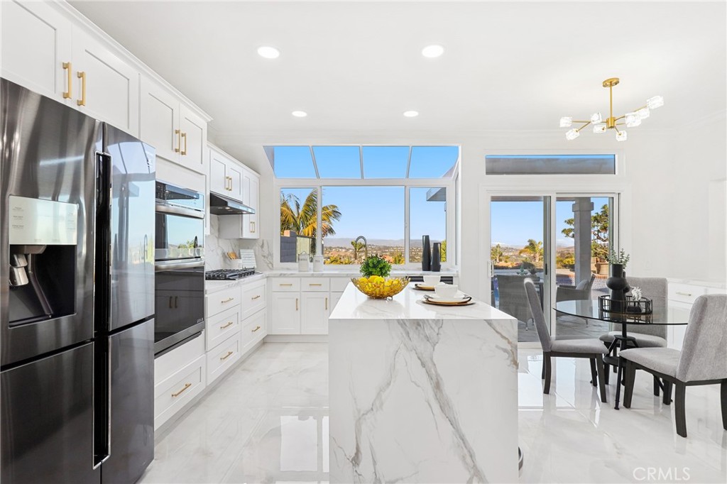 30352 Anamonte Laguna Niguel, CA 92677 - Photo 11 of 43 a kitchen with stainless steel appliances kitchen island granite countertop a refrigerator and a stove top oven