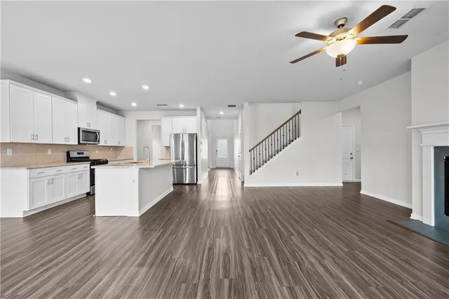 a view of kitchen with sink microwave and wooden floor