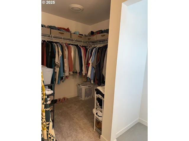 a view of walk in closet with clothes and shoes