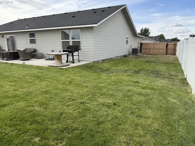 a view of a backyard with table and chairs and wooden fence