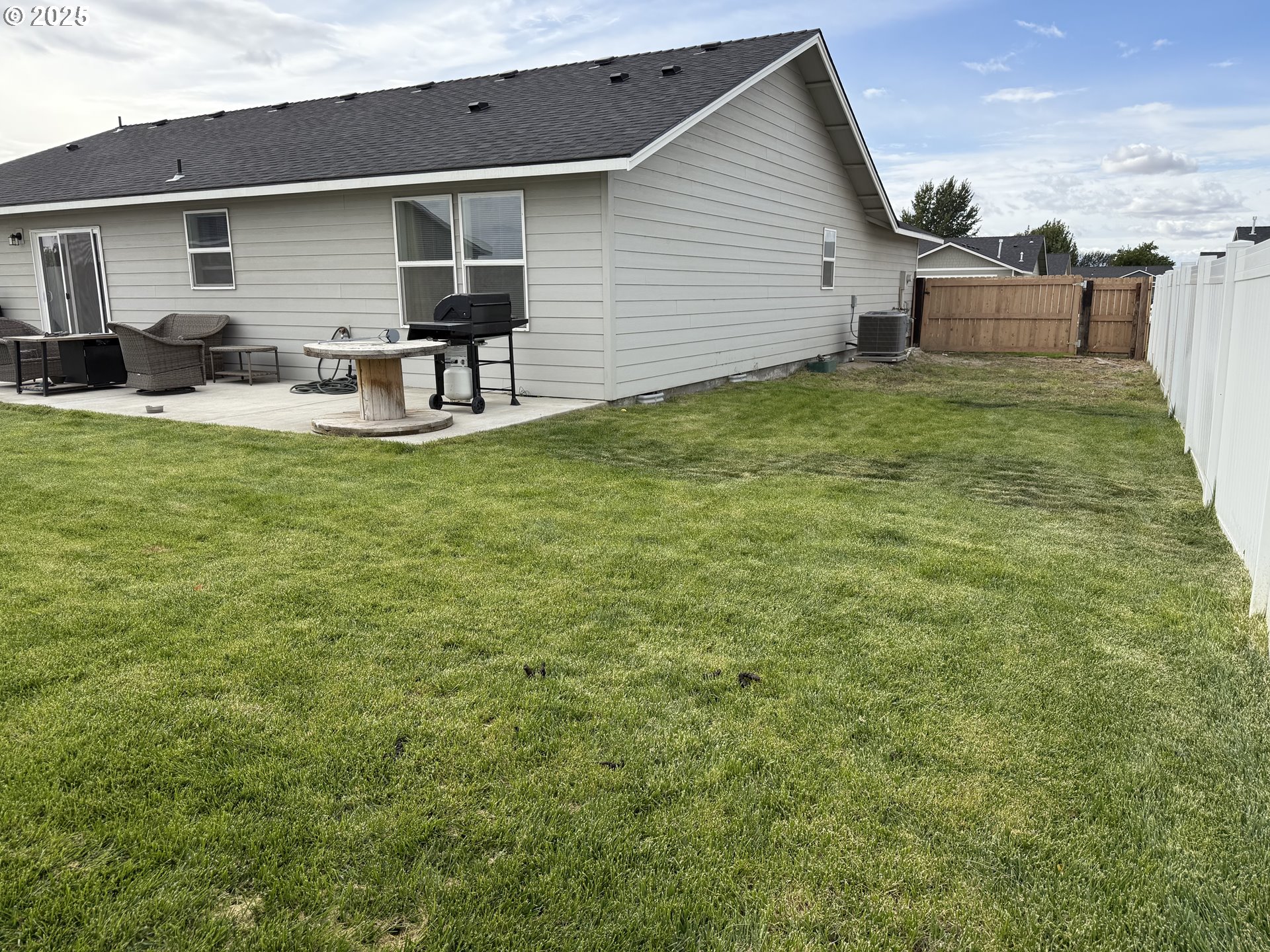 213 River Ridge Drive Boardman, OR 97818 - Photo 17 of 17 a view of a backyard with table and chairs and wooden fence