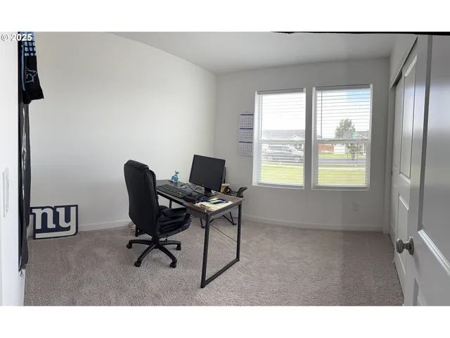 a view of a workspace with furniture and a window