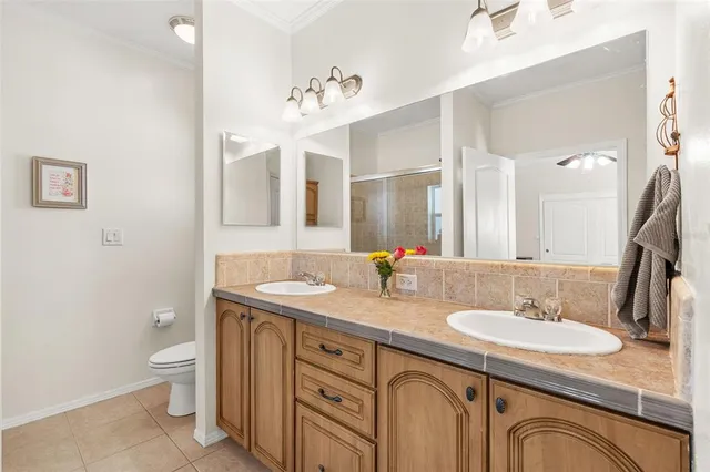 a bathroom with a granite countertop sink a toilet and a mirror