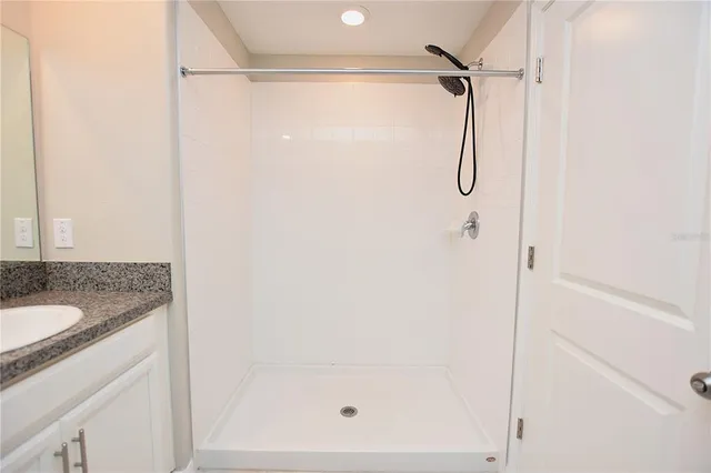 a bathroom with a granite countertop shower and a sink