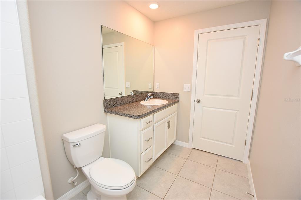 5643 Keaton Springs Drive Lakeland, FL 33811 - Photo 25 of 39 a bathroom with a granite countertop toilet a sink and a mirror