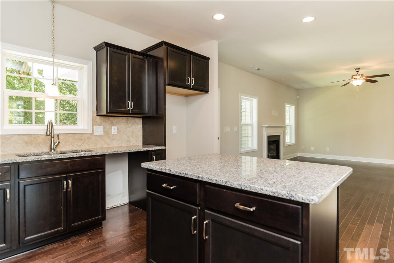 3413 Grosbeak Way Raleigh, NC 27616 - Photo 14 of 25 a kitchen with stainless steel appliances granite countertop a sink dishwasher a stove and a refrigerator with wooden floor