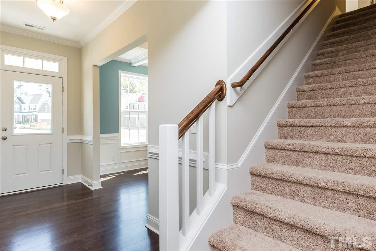 3413 Grosbeak Way Raleigh, NC 27616 - Photo 4 of 25 a view of staircase with wooden floor and white walls
