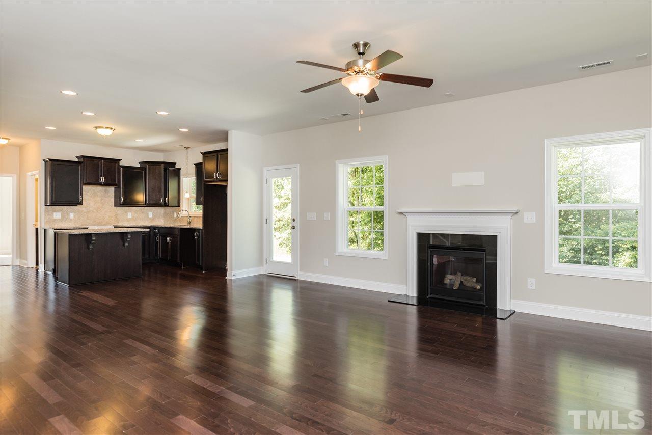3413 Grosbeak Way Raleigh, NC 27616 - Photo 9 of 25 an open space with kitchen fireplace and wooden floor