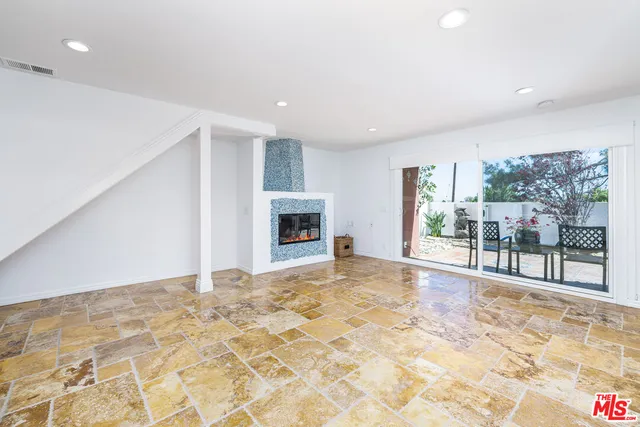 a view of an empty room with a fireplace and a window